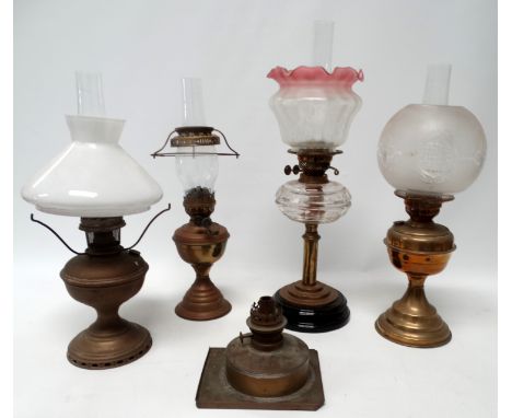 A late Victorian oil lamp - with a clear glass faceted reservoir on a brass column and pink edged shade, height 60cm, togethe