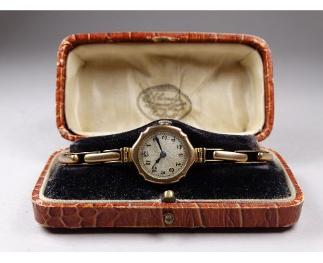 A ladies 9ct yellow gold cased wristwatch - the silvered engine turned dial set out in Arabic numerals, on a 9ct yellow gold 
