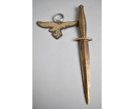 A Embroidered Nazi Eagle and Swastika Badge, Novelty Letter Opener in the Form of a Commando Dagger together with an Aluminiu