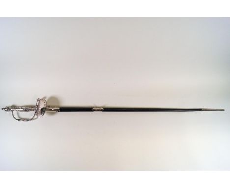 A Court style sword in black scabbard with steel pommel, grip and hilt, in chamois slip and brown leather carrying case