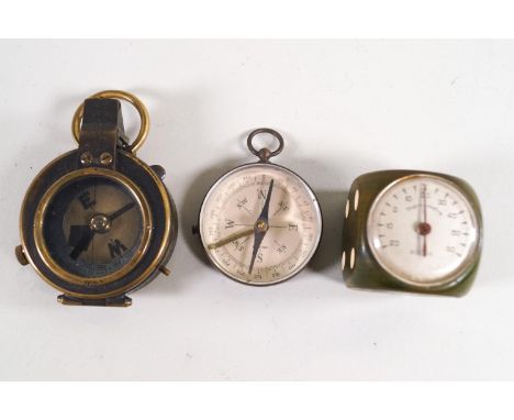 A Rolex thermometer in a bakelite dice, a brass cased field compass with mother of pearl chapter dial in a leather case and a