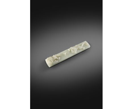 A CHINESE PALE CELADON JADE 'DRAGON' SCROLL WEIGHT 18TH CENTURY  The long rectangular slab worked with curved ends, carved in