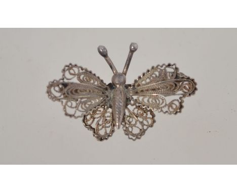 A vintage silver filigree butterfly miniature brooch with a loop clasp, marked "800" and measuring 2.7cms long.
