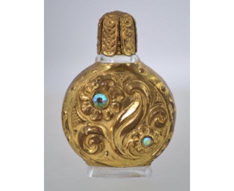 A vintage miniature perfume bottle, presumed 1960s, with pressed glass, gold tone metal and rhinestones. It has been marked w