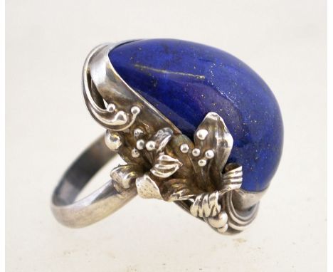 A large vintage silver and lapis lazuli ring with a lily design setting, marked "925".