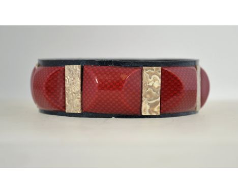 An unusual 1920s celluloid bangle, composed of pieces of printed, marbled and glittered celluloid.