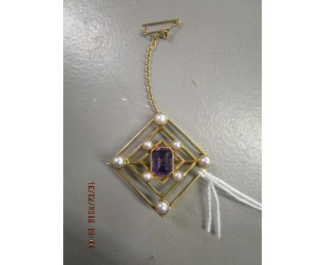 A yellow metal brooch set with a central amethyst surrounded by two sets of four pearls, on a safety chain, total weight 8.5g