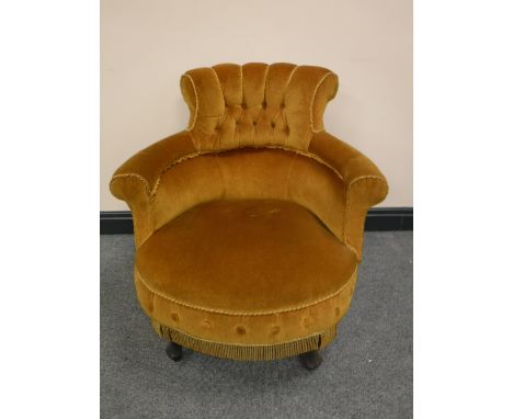 A Victorian armchair upholstered in gold button fabric 