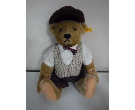 A Steiff brown mohair bear wearing glasses and a hat, signed to the foot, length 35 cm.