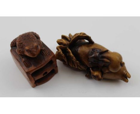 TWO LATE 20TH CENTURY JAPANESE CARVED WOOD NETSUKE, one depicts rabbits upon a fruit, the other a toad (2) 