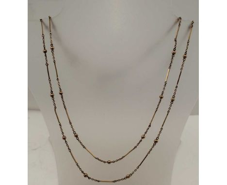 A VICTORIAN / EDWARDIAN YELLOW METAL GUARD CHAIN, decorative ball, chain and bar link with watch clip, 134cm longCondition re