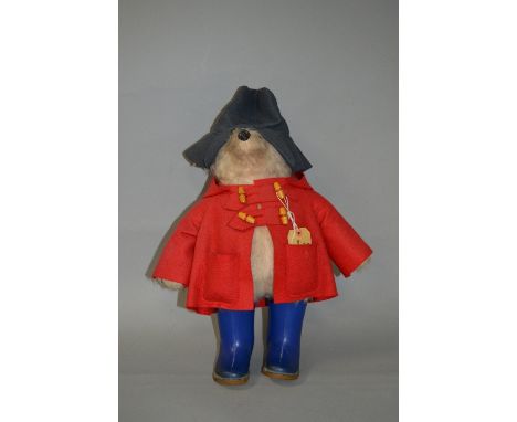 A GABRIELLE DESIGNS PADDINGTON BEAR, red duffle coat, blue hat and blue Dunlop Wellingtons, complete with card label, Gabriel