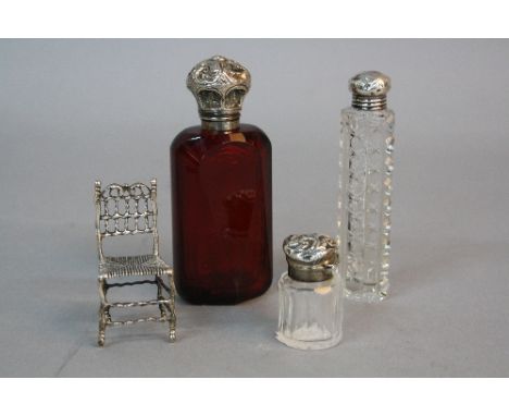 A LATE 19TH CENTURY RUBY GLASS SCENT BOTTLE, facet cut, white metal mounts, height approximately 10.5cm, together with a clea