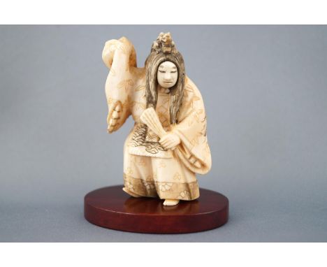 An early 20th century ivory netsuke of an actor with revolving mask, signed to the base, 7cm high