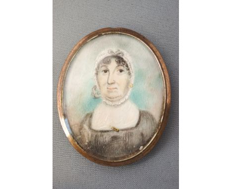 An early 19th century portrait miniature of a lady, watercolour on ivory within gilt metal locket, overall 6cm x 4.5cm