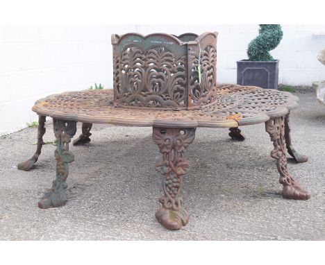 A four section circular garden tree seat, of cast metal with stylised flowers and acanthus design, 75cm high to seat back, di