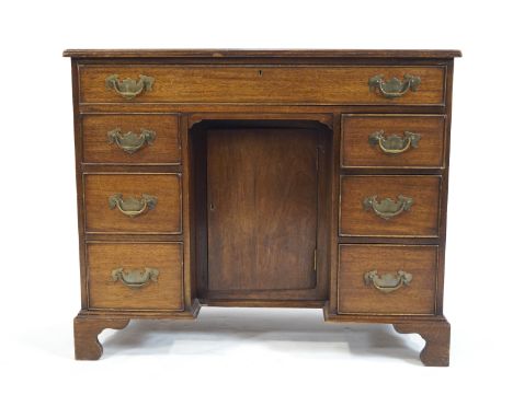 A George III style mahogany kneehole desk with one long drawer above three drawers to either side, on bracket feet, 76cm high