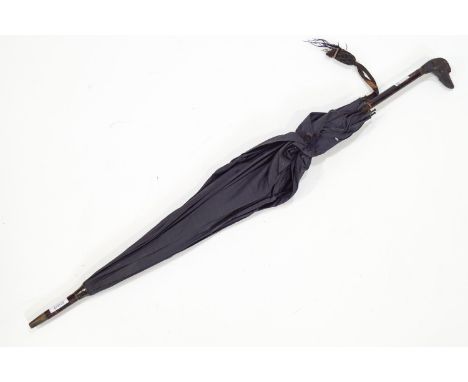 A late 19th century ladies parasol with carved dogs head finial, 70cm high