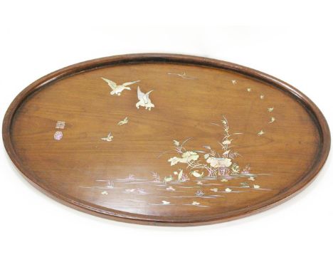 A Japanese oval hardwood tray, inlaid with mother of pearl with geese in flight above a river, 23cm wide, together with a sim