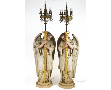 A pair of ceramic torcheres with realistic polychrome painted finish modelled in the forms of Angels dressed in dalmatics, st