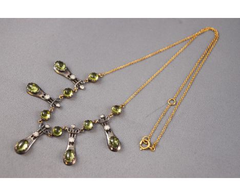 A yellow and white metal centrepiece necklace, set with oval and round cabochon cut peridot and round brilliant cut diamonds.