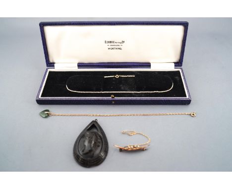 A collection of jewellery to include a large carved jet pendant (untested) a single strand of 2mm seed pearls, a nephrite jad