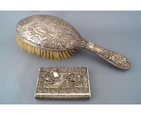 A silver handled hairbrush, profusely decorated with a hunting scene of the kill, Birmingham 1903, 25cm long, together with a