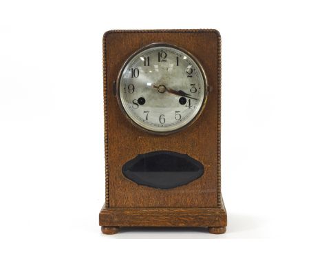 A 1930's oak cased mantel clock, with silvered dials, striking on a gong with pendulum and key, 28cm high