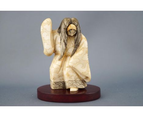 An early 20th century ivory netsuke of an actor with revolving mask, signed to the base, 7cm high