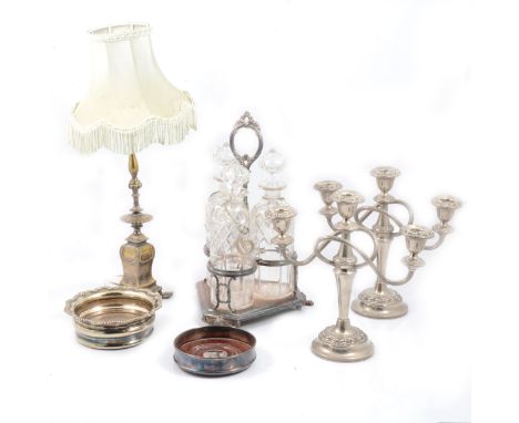 An electroplated three bottle Tantalus, one glass decanter damaged; a pair of three-light candelabra; plated coaster; plated 