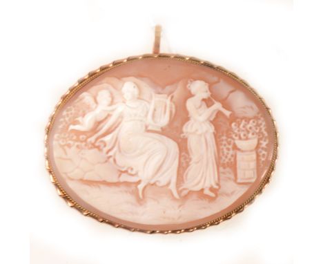 An oval carved shell cameo brooch, a garden scene with figures playing musical instruments, set in a yellow metal frame with 