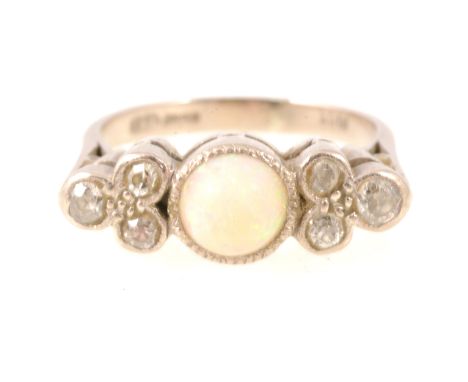 An opal and diamond ring, a 7mm round cabochon cut opal millegrain set with three old cut diamonds to each side also millegra