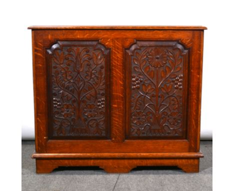 An oak coffer, rectangular hinged lid with a moulded lid, two carved panels to the front, on bracket feet, width 93cm, depth 