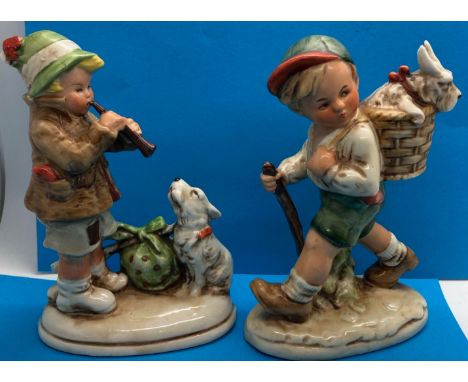 Two figurines in the Hummel/Goebel style, including Boy playing flute to dog and one other, H: 15 cm. P&amp;P Group 2 (£18+VA