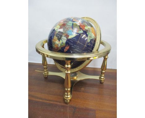 A globe inset with semi precious gem stones and with a brass frame, 32cm h x 32.5cm wLocation: 