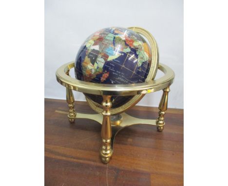 A globe inset with semi precious gem stones and with a brass frame, 32cm h x 32.5cm wLocation: 