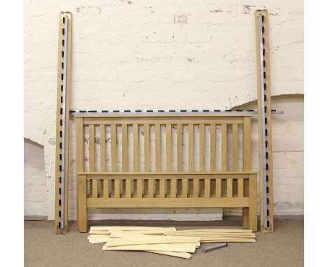 A good quality light oak king size bed frame raised on square cut legs.