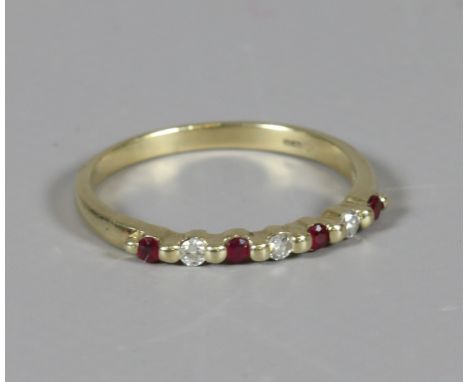 A 9 carat gold ruby and diamond line ring set with seven stones. Size Q. 