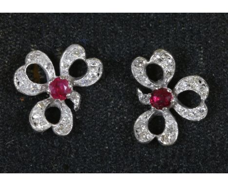 A cased pair of hall marked 18ct white gold ruby and diamond set clover leaf stud earrings.