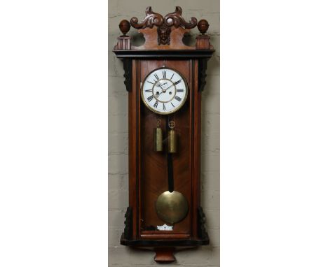 A 19th century walnut cased twin weight eight day Vienna wall clock. With carved pediment, ebonized mouldings and having enam