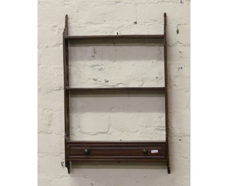 A mahogany three tier wall shelf with open fret sides and single drawers.