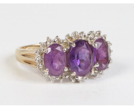 A ladies 9ct gold amethyst three stone diamond surround dress ring UK size J1/2.