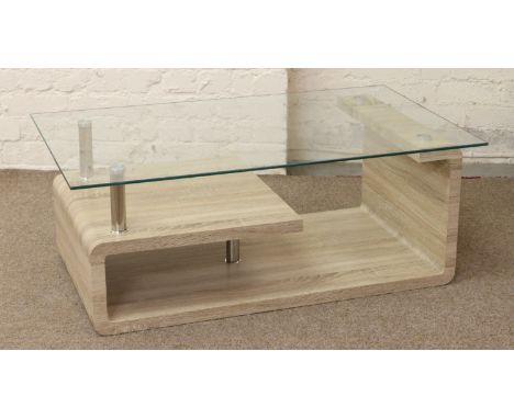 A glass top modernist light oak effect coffee table.