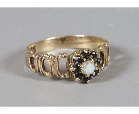 A 9ct gold ring with open work shoulders set with garnet and an opal UK size M.