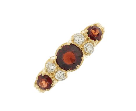 An 18ct gold graduated garnet three-stone dress ring, with brilliant-cut diamond double spacers and openwork gallery, estimat