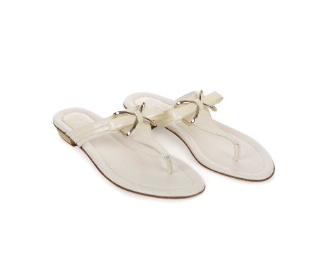 Christian Dior, a pair of unworn thong sandals, crafted from cream leather, with pale gold-tone hardware and front bow detail