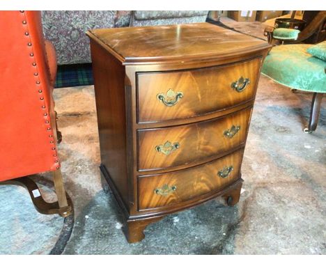 A Burton Reproductions Ltd mahogany small chest of drawers, the moulded top with a bowed front above three drawers, some lack