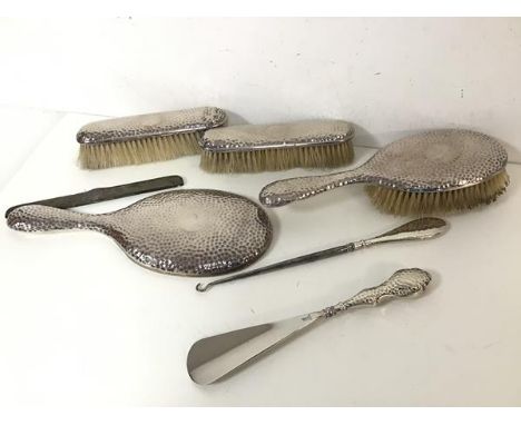 An Edwardian London silver toiletry set including hairbrush, hand mirror, clothes brushes, shoe horn, button hook, comb cover