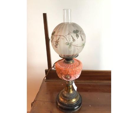 An Edwardian oil lamp with globular glass shade with applied flower and scrolling vine decoration, converted to electricity (