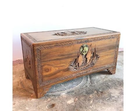 A Chinese hardwood trunk with maritime scene carved to top and sides within Chinese design border, on moulded bracket feet (5
